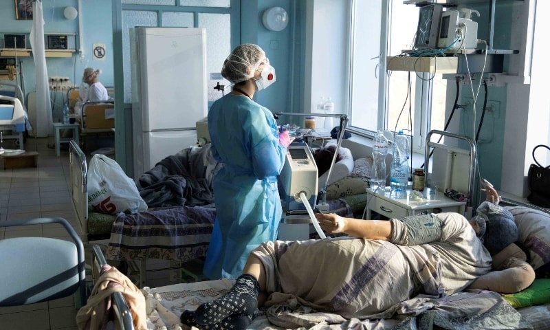 A medical specialist treats a patient suffering from the coronavirus at the intensive care unit of the City Clinical Hospital Number 3 in Kyiv, Ukraine on October 26. &mdash; Reuters
