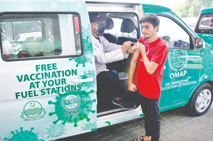 LAHORE: A person being injected Covid-19 vaccine at a petrol pump on Thursday as health workers at the Oil Marketing Association of Pakistan&rsquo;s vans have started vaccinating consumers at different petrol pumps. As per the pilot project there are four vans, but they will be increased later to achieve a target of 100,000 vaccinated people through these vans by the end of December.&mdash;APP