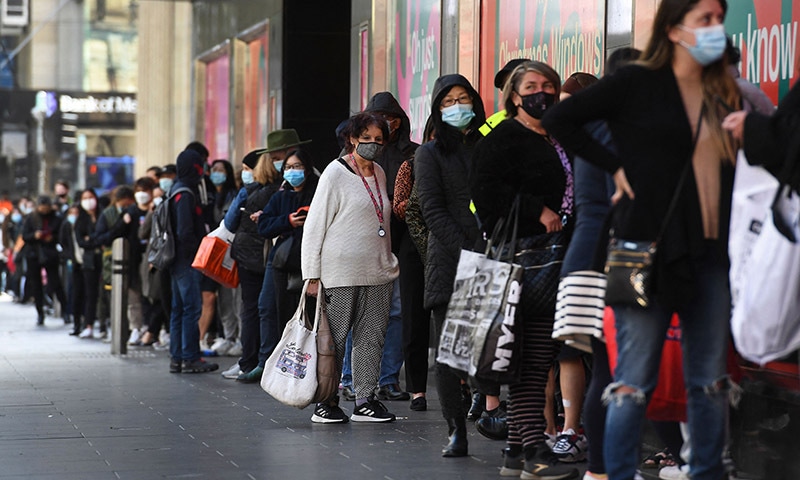 People queue outside a department store in Melbourne on Thursday as the city further lifts Covid restrictions allowing non-essential retail shops to open. — AFP