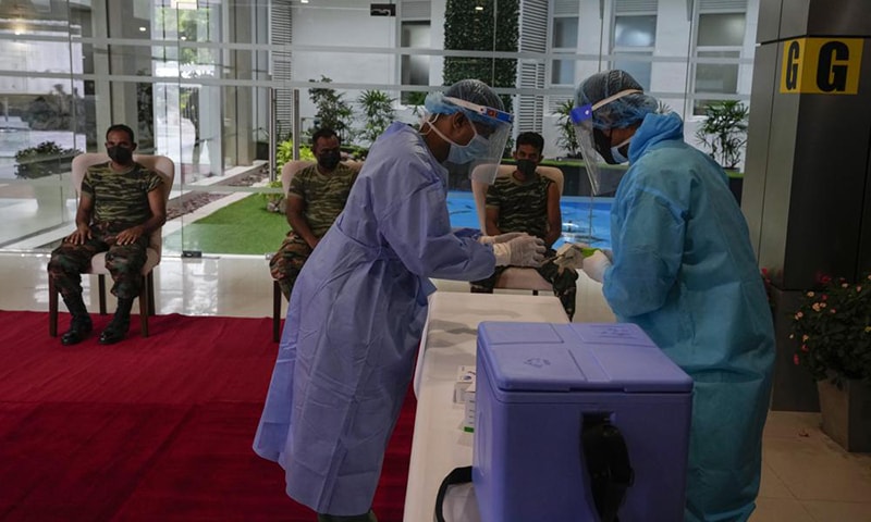 Sri Lankan army soldiers wait to receive the third jab of anti-coronavirus vaccine in Colombo, Sri Lanka on Monday. &mdash; AP