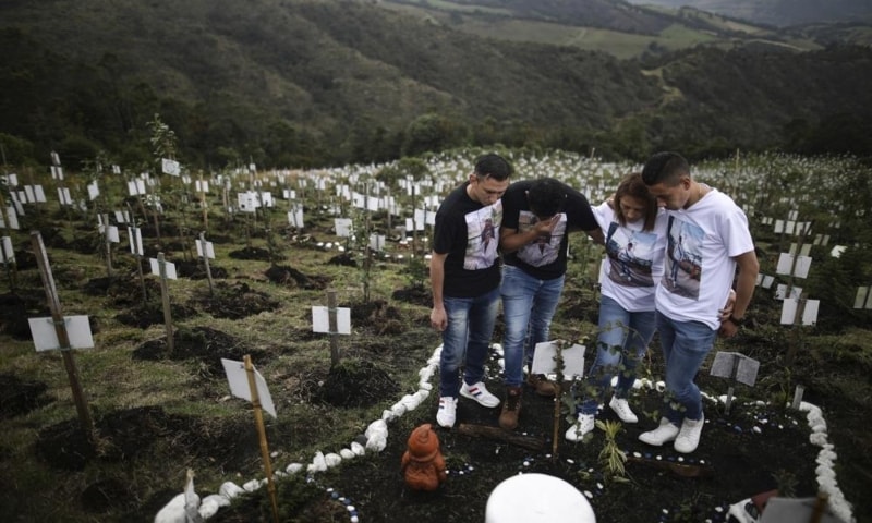 Relatives of a person who died of Covid-19 visit where he was buried on a hill at the El Pajonal de Cogua Natural Reserve, in Cogua, north of Bogota, Colombia, Oct 25. &mdash; AP