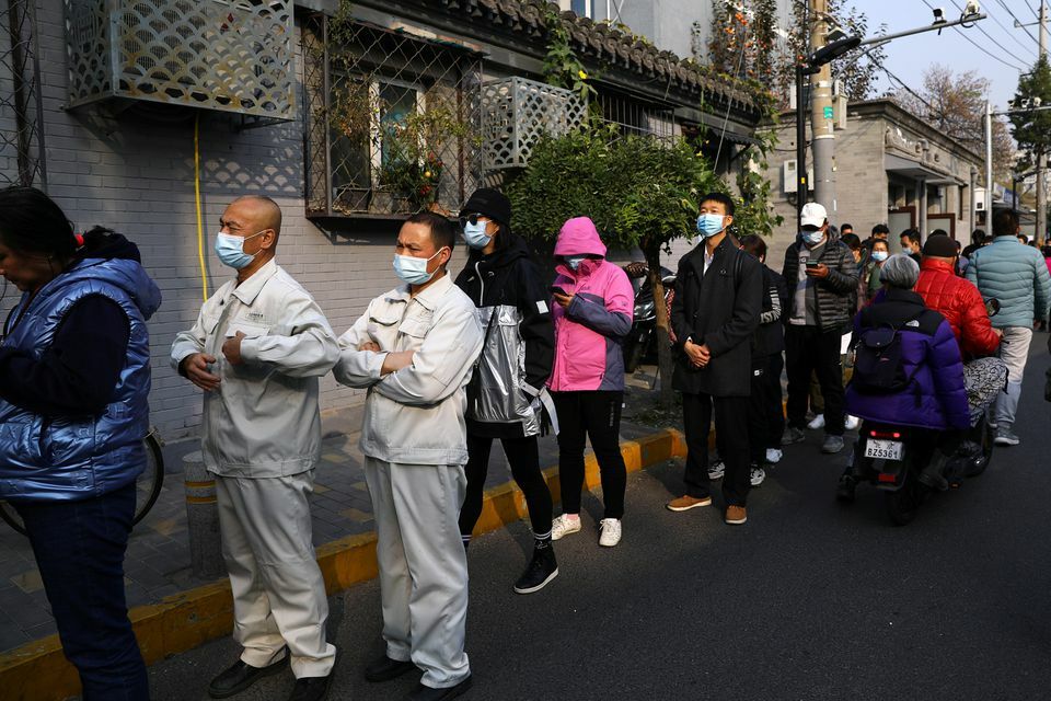 People line up outside a vaccination site after the city started offering booster shots of the vaccine against the coronavirus to vaccinated residents, in Beijing, China, October 29. — Reuters
