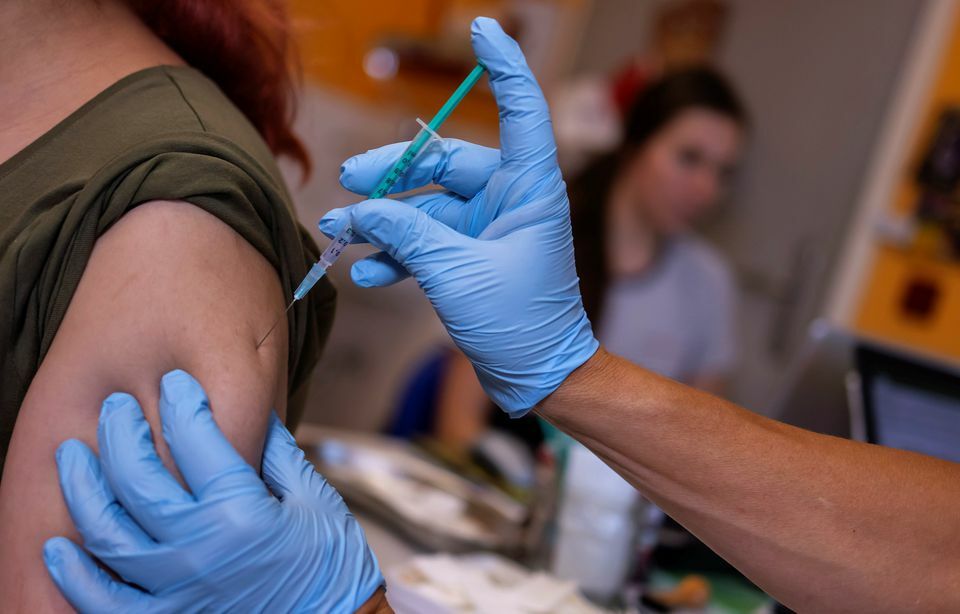 A doctor vaccinates a woman with a coronavirus vaccine in his office in Berlin, Germany, November 2. — Reuters