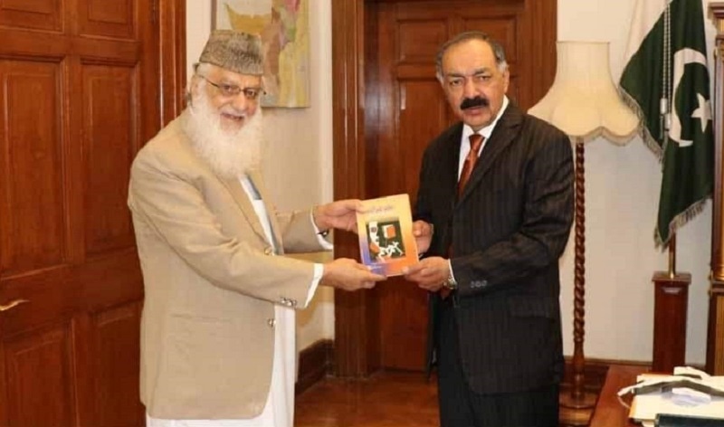 A file picture of Habiatullah Halimi presenting his book to former Balochistan governor Amanullah Yasinzai. — APP/File