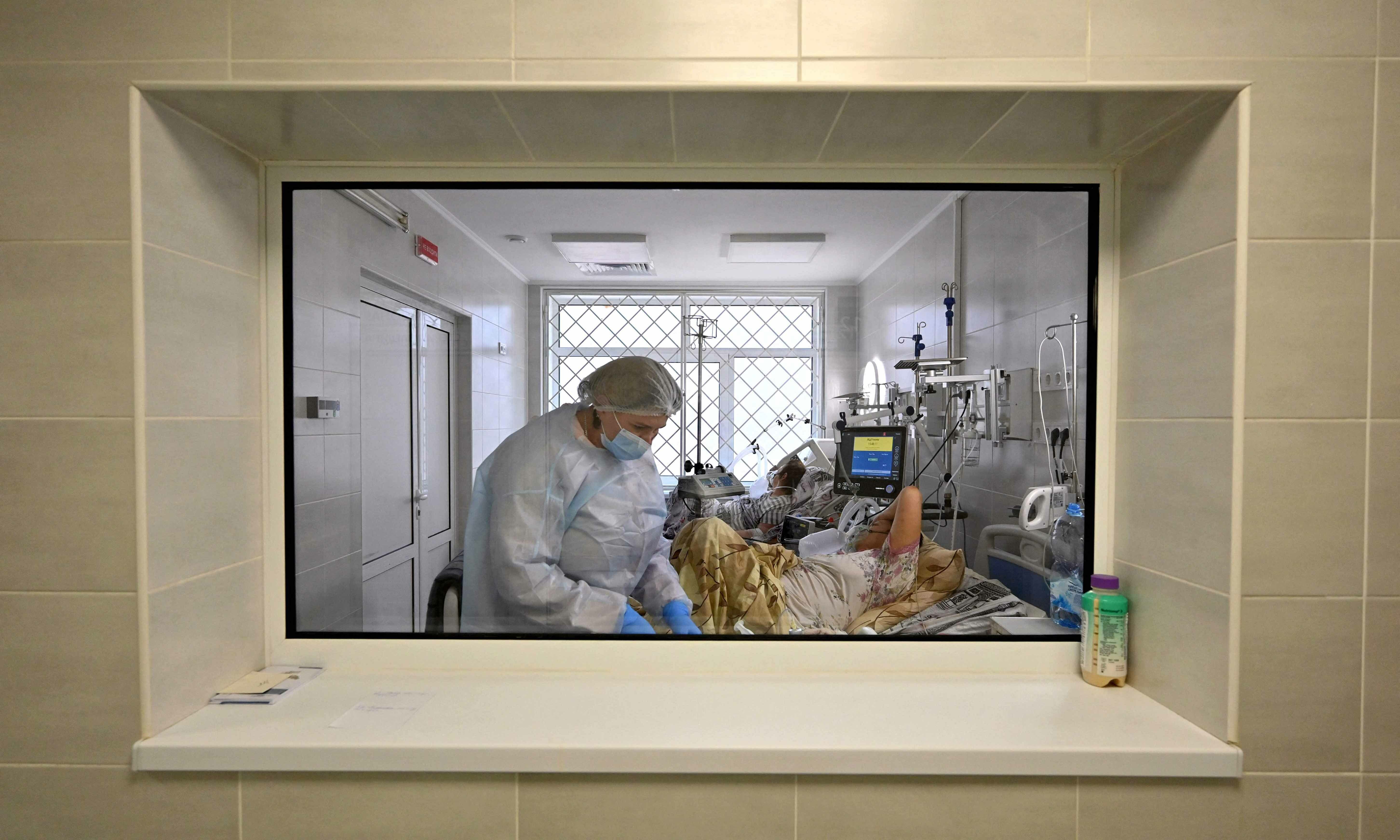 Medical personnel provides medical assistance to a Covid-19 patient inside the intensive care unit in an hospital in Kiev on November 1. — AFP