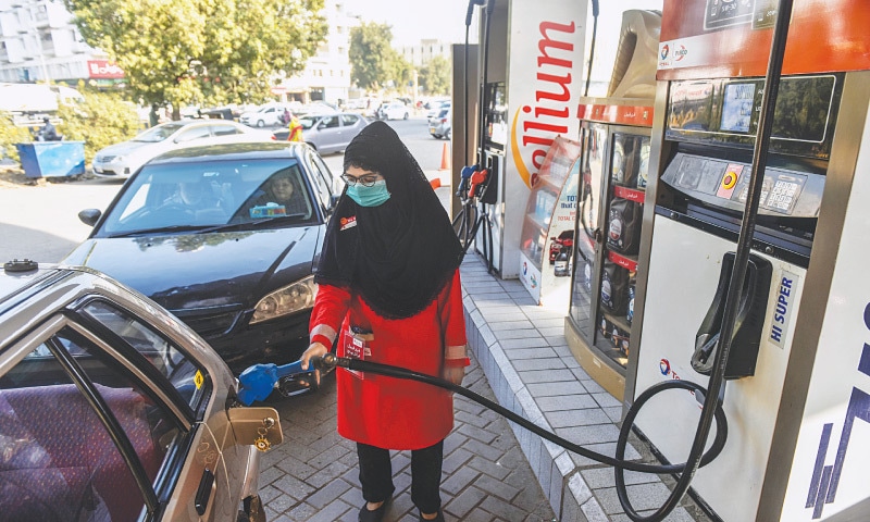 One of the four women workers is busy filling petrol in cars at the fuel station in Clifton on Saturday.&mdash; Fahim Siddiqi / White Star