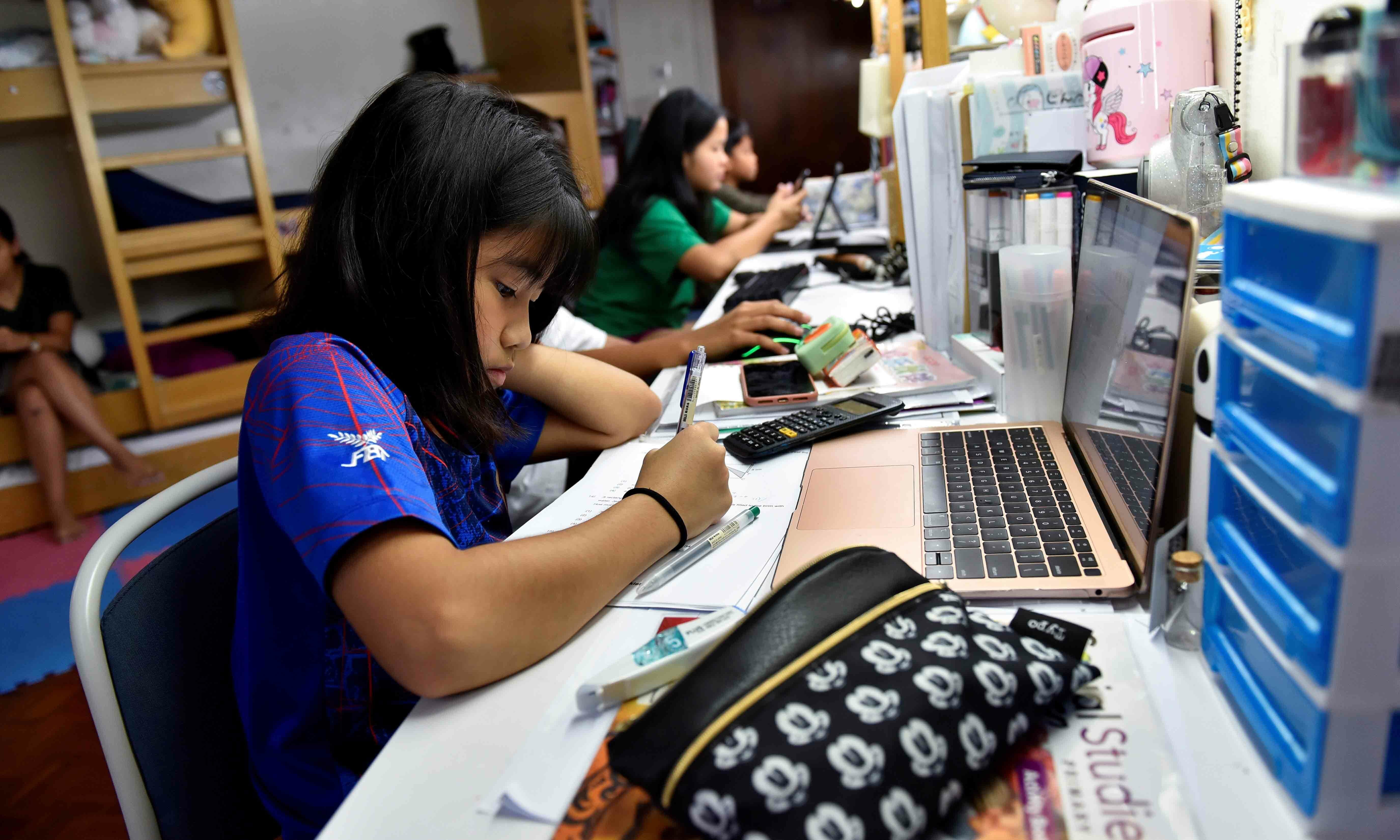 Kiera Arwen Ong, 11, and her siblings work on their home-based learning assignments after all schools were shut, due to the surge in coronavirus cases in Singapore on May 20. &mdash; Reuters