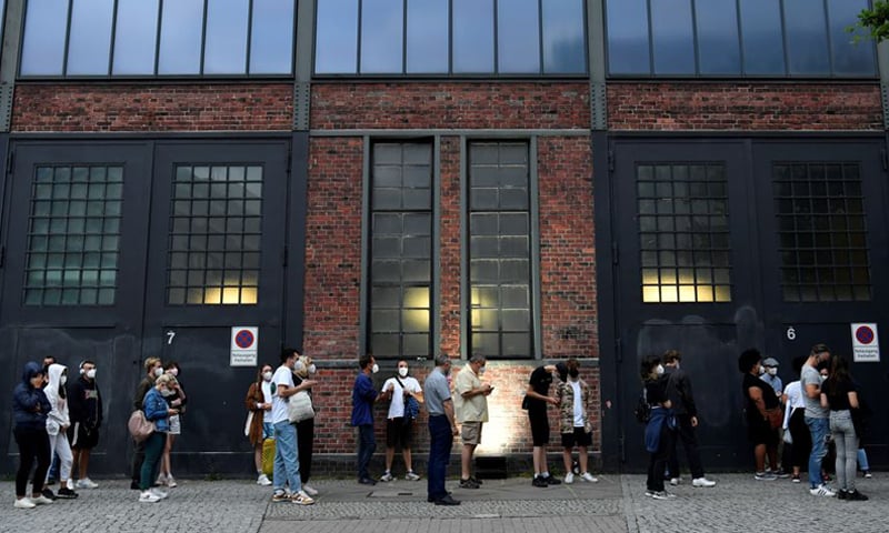 In this August 9, 2021 file photo, people queue to receive a vaccine against Covid-19 during a night of vaccinations with music at the Arena Treptow vaccination centre in Berlin, Germany. &mdash; Reuters/File
