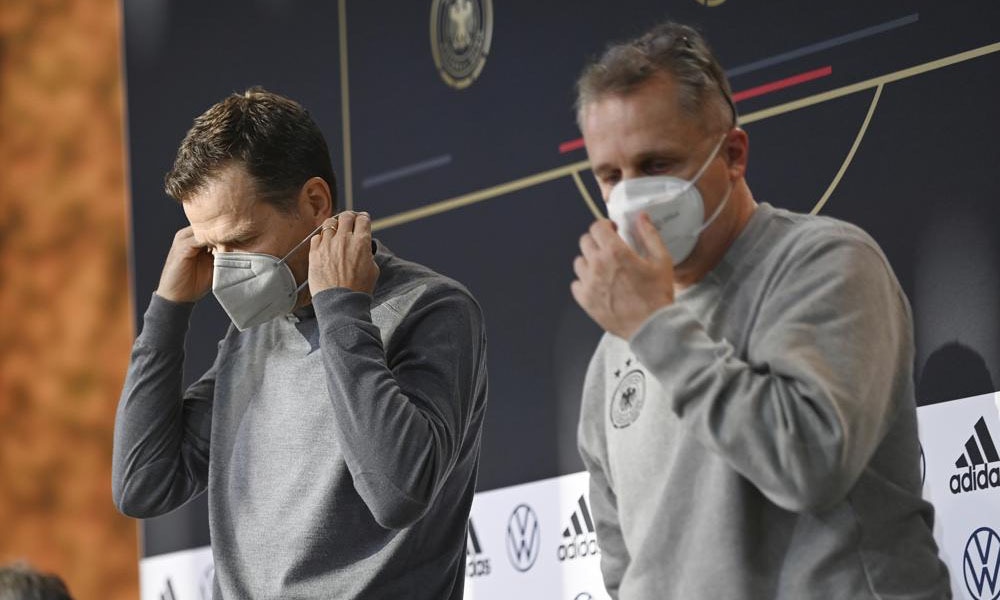 DFB director Oliver Bierhoff, left, and DFB doctor Tim Meyer leave a press conference wearing masks in Wolfsburg, Germany, prior the World Cup qualifying match against Liechtenstein, on Tuesday. — AP