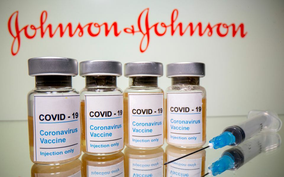 Vials with a sticker reading, "Covid-19 / Coronavirus vaccine / Injection only" and a medical syringe are seen in front of a displayed Johnson & Johnson logo in this illustration. — Reuters/File