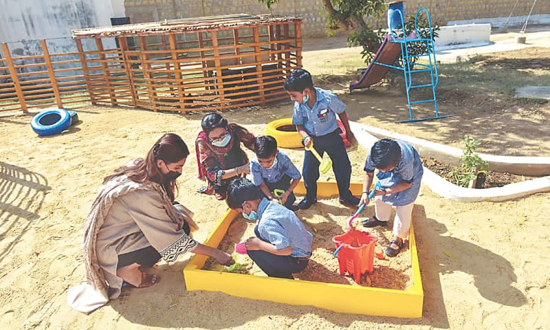 The sandbox in the Sensory Garden cannot be resisted by children as well as  Barrister Haya Zahid and a volunteer at the Early Learning Centre at the prison. &mdash;Fahim Siddiqi / White Star