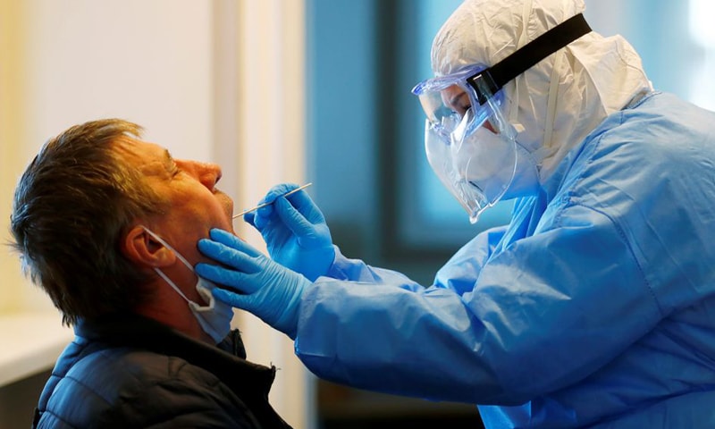In this file photo, a healthcare worker takes a swab from a passenger returning with a ferry from Germany to be tested for Covid-19 in Liepaja, Latvia. — Reuters/File