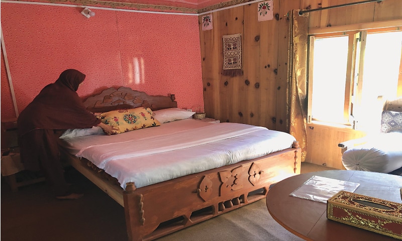 Abida Ghulam Jilani, a host in Sharda, makes the guestroom bed