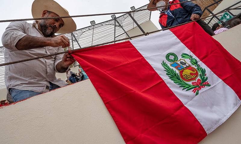 Spectators hang a Peruvian flag over a stage rim prior to the opening bullfight of the 2021 season at the Esperanza bullring in Pachacamac, Peru on November 13. &mdash; AFP