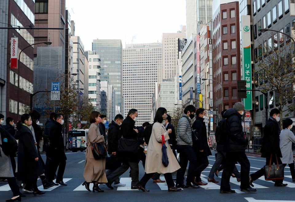 Pedestrians wearing protective masks make their way during commuting hour at a business district in Tokyo, Japan, January 7. &mdash; Reuters/File