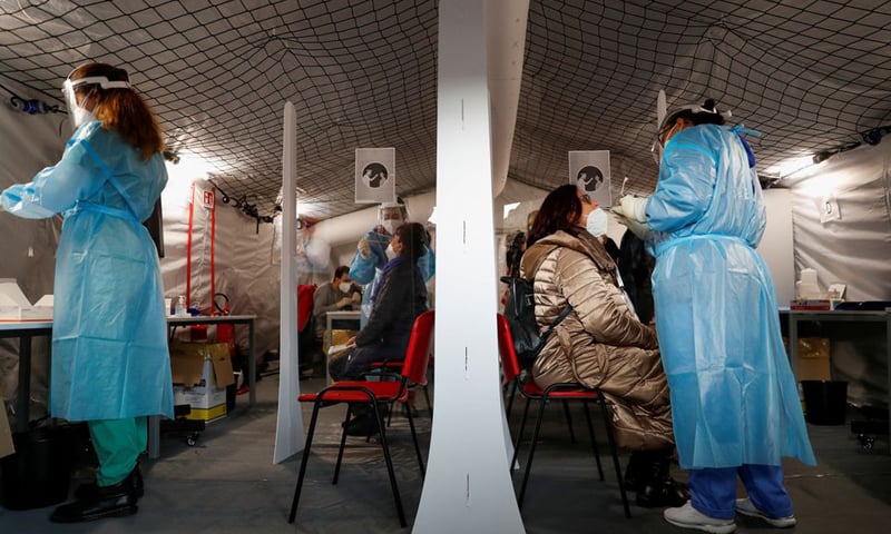 in this file photo, healthcare workers take nasal swab samples from people as they need to be tested to pass the barricade for the non-stop "Covid-free" direct train from Rome to Milan. &mdash; Reuters/File