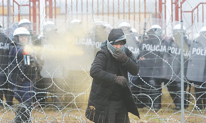 A POLISH law enforcement officer uses tear gas as migrants attempt to cross from Belarus into Poland.&mdash;Reuters