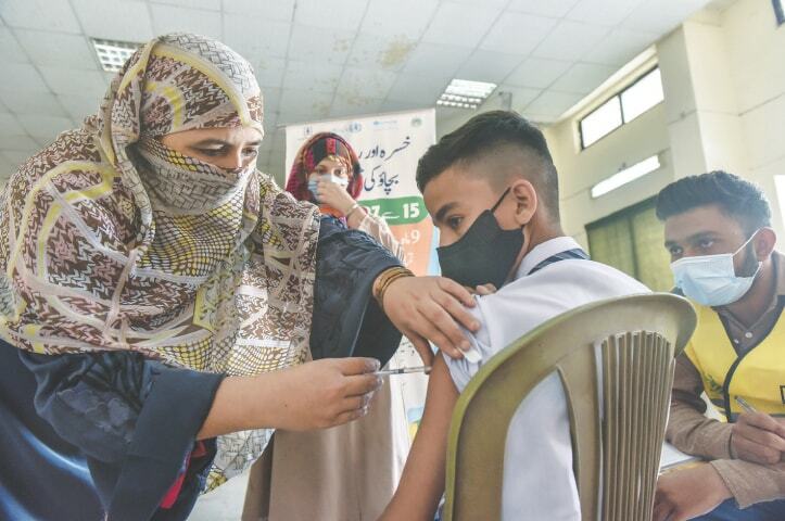 A woman administers the anti-measles vaccine to a student at a North Nazimabad school in Karachi. — Fahim Siddiqi / White Star