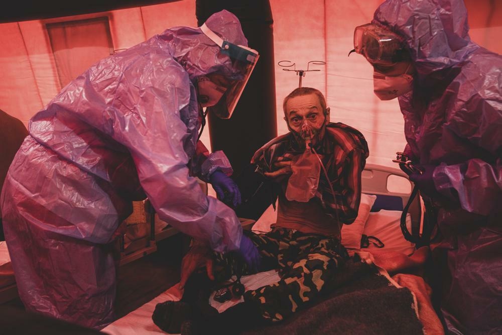 Medical staff treat a coronavirus patient in tents erected adjacent to a hospital in the city of Kakhovka, Ukraine on Oct 31, 2021. &mdash; AP