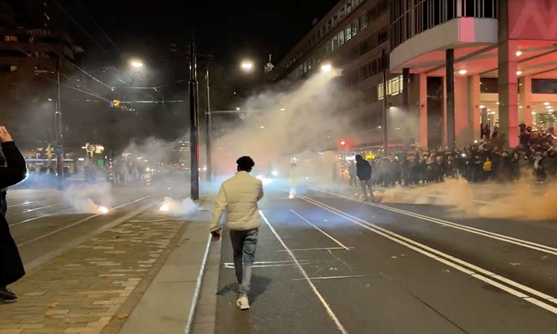 Protesters watch smoke flares on a street in Rotterdam, Netherlands on Sunday, in this screen grab obtained from a social media video. — Reuters