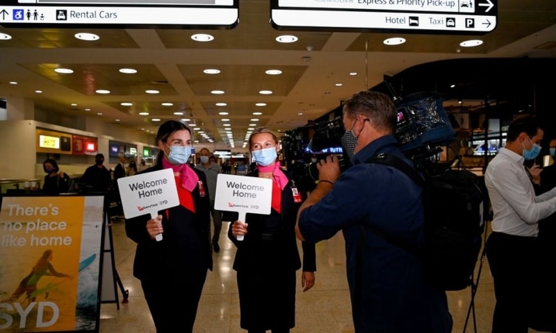 Airport staff hold up welcome signage as the first international travellers arrive at Sydney Airport in the wake of coronavirus border restrictions easing in Sydney, Australia, November 1. — Reuters
