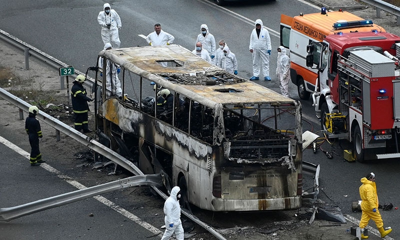 Officials work at the site of a bus accident, in which at least 46 people were killed, on a highway near the village of Bosnek, south of Sofia, on Tuesday. — AFP