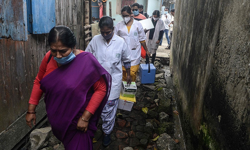 Health workers walk along an alley during a door-to-door Covid-19 coronavirus vaccination drive in Siliguri, India on Tuesday. — AFP