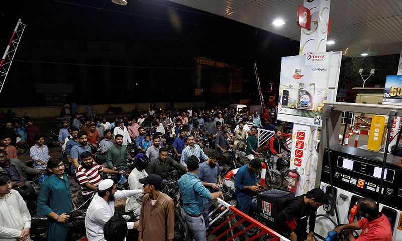 People wait for their turn to get petrol at a petrol station, after Pakistan Petroleum Dealers Association (PPDA) announced a countrywide strike, in Karachi on Wednesday. — Reuters