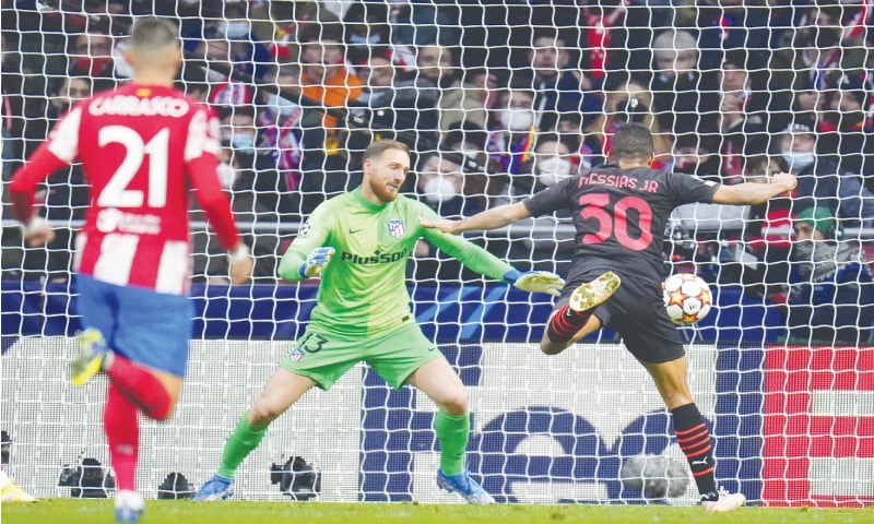 MADRID: Junior Messias (R) of AC Milan scores during their Champions League group B match against Atletico Madrid at the Wanda Metropolitano Stadium.—AP