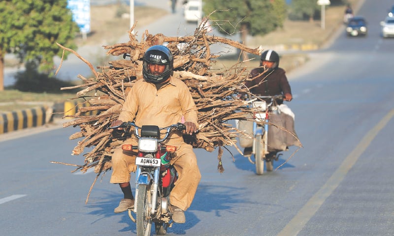 ISLAMABAD: Amid a gas shortage in the country, a man carries firewood on his motorbike on Friday. — AP