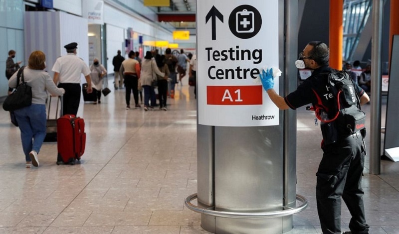A worker sanitises a sign at the International arrivals area of Terminal 5 in London's Heathrow Airport, Britain, on Aug 2, 2021.