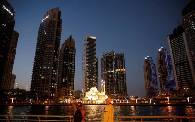 In this file photo, tourist take photos of a mosque across the Dubai Marina, surrounded by high towers of hotels, banks and office buildings, in Dubai, UAE on Dec 11, 2017. — Reuters In this file photo, tourist take photos of a mosque across the Dubai Marina, surrounded by high towers of hotels, banks and office buildings, in Dubai, UAE on Dec 11, 2017. — Reuters