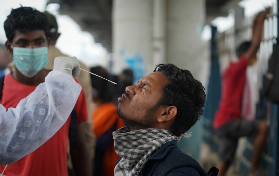 A health worker in personal protective equipment collects a swab sample from a man during a rapid antigen testing campaign for the coronavirus at a railway station in Mumbai, India, December 1. — Reuters