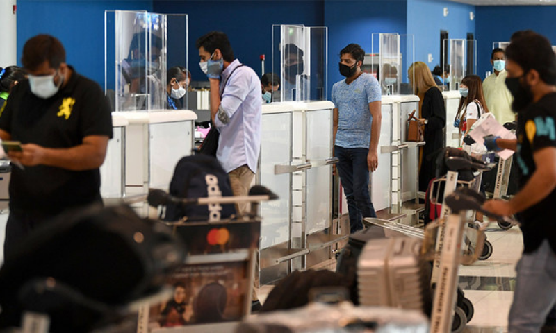 Pakistani nationals check in at the Dubai International Airport before leaving the Gulf emirate on a flight back to their country. — AFP/File