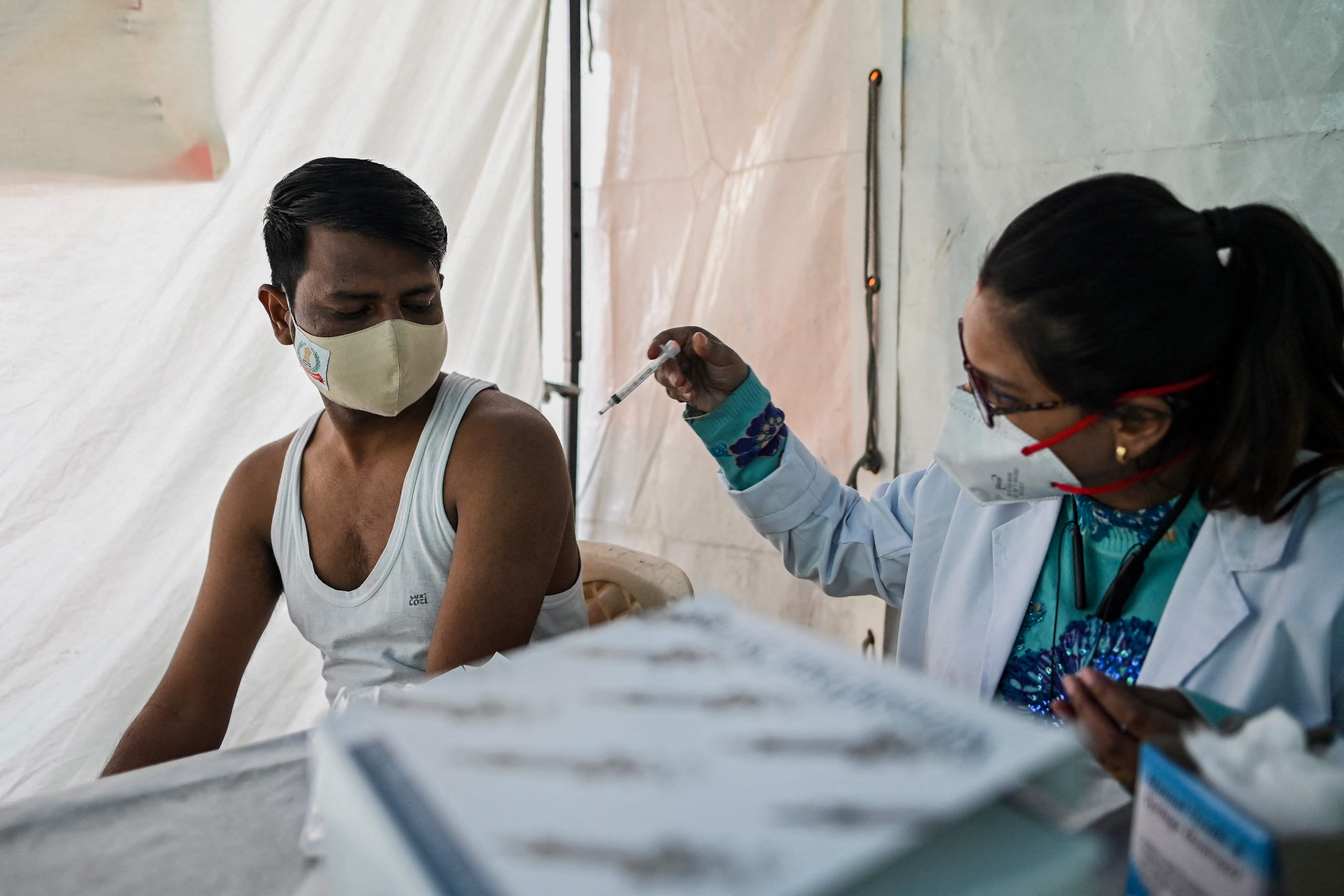 A man gets himself inoculated with the coronavirus vaccine at a railway station in New Delhi on December 4. — AFP