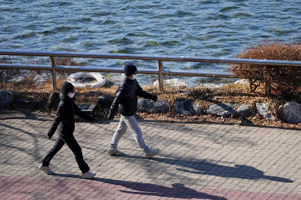 Visitors wearing face masks as a precaution against the coronavirus, walk at a park in Goyang, South Korea, on Dec 4. — AP