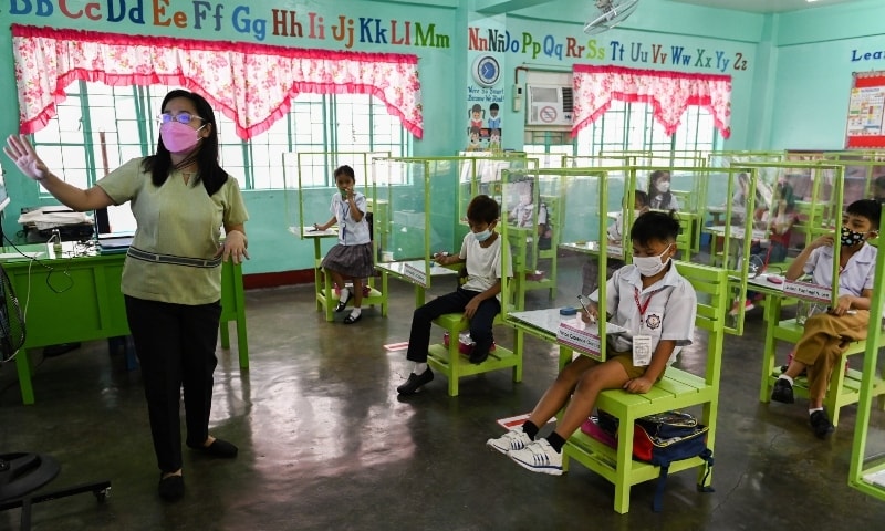 Students seated on chairs with plastic barriers attend a class as several schools in the Philippines' capital reopen for the first time since the coronavirus pandemic, in Pasay City, Metro Manila on December 6. — Reuters