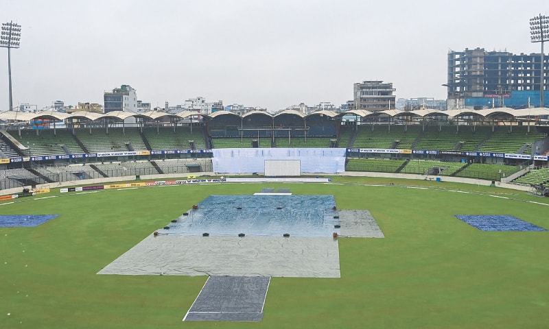 DHAKA: The pitch is covered with plastic sheets as rain interrupts the start of the third day of the second Test between Bangladesh and Pakistan at the Sher-e-Bangla National Stadium on Monday.—AFP