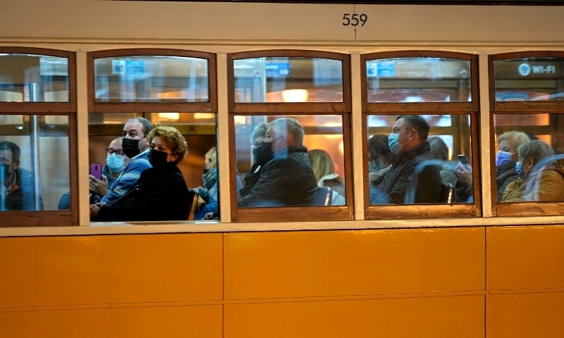 People wearing face masks ride a tram in downtown Lisbon on December 6. — AP