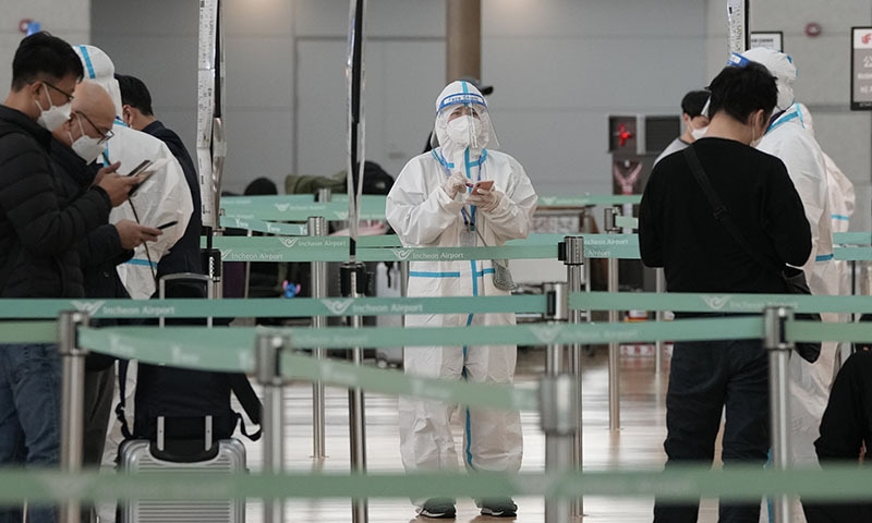 A quarantine officer wearing protective gear waits to guide travellers at the departure hall of the Incheon International Airport in Incheon, South Korea, on Tuesday. — AP