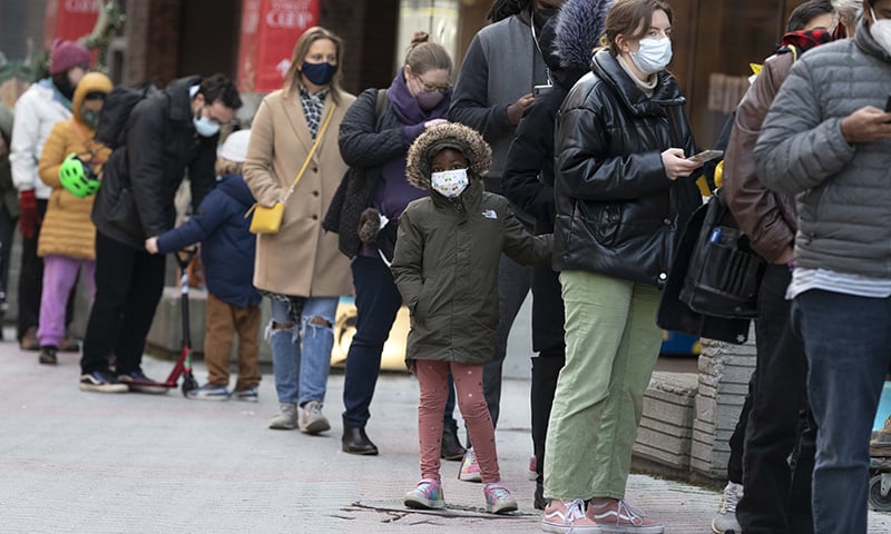 People wait in line outside a Covid-19 walk-in testing site in Cambridge, US. &mdash; AP