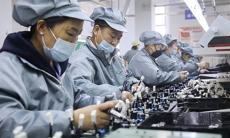 Workers wearing face masks assemble electronic parts at a factory in Huaibei in central China's Anhui Province. — AP/File