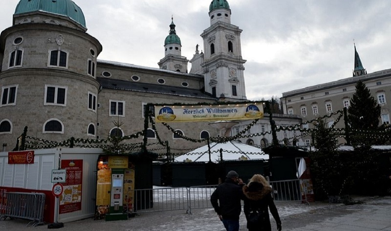 People walk past closed booths after the traditional Christmas market was closed due to the fourth Covid-19 lockdown in Salzburg, Austria, Dec 8, 2021.