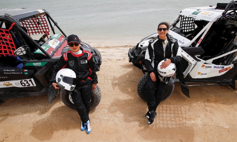 DHAHRAN: A March 5 picture shows Saudi women Mashael Nasser Al-Obaidan and Dania Akeel posing for photographers during the first stage of Sharqiyah International Baja Rally. — Reuters