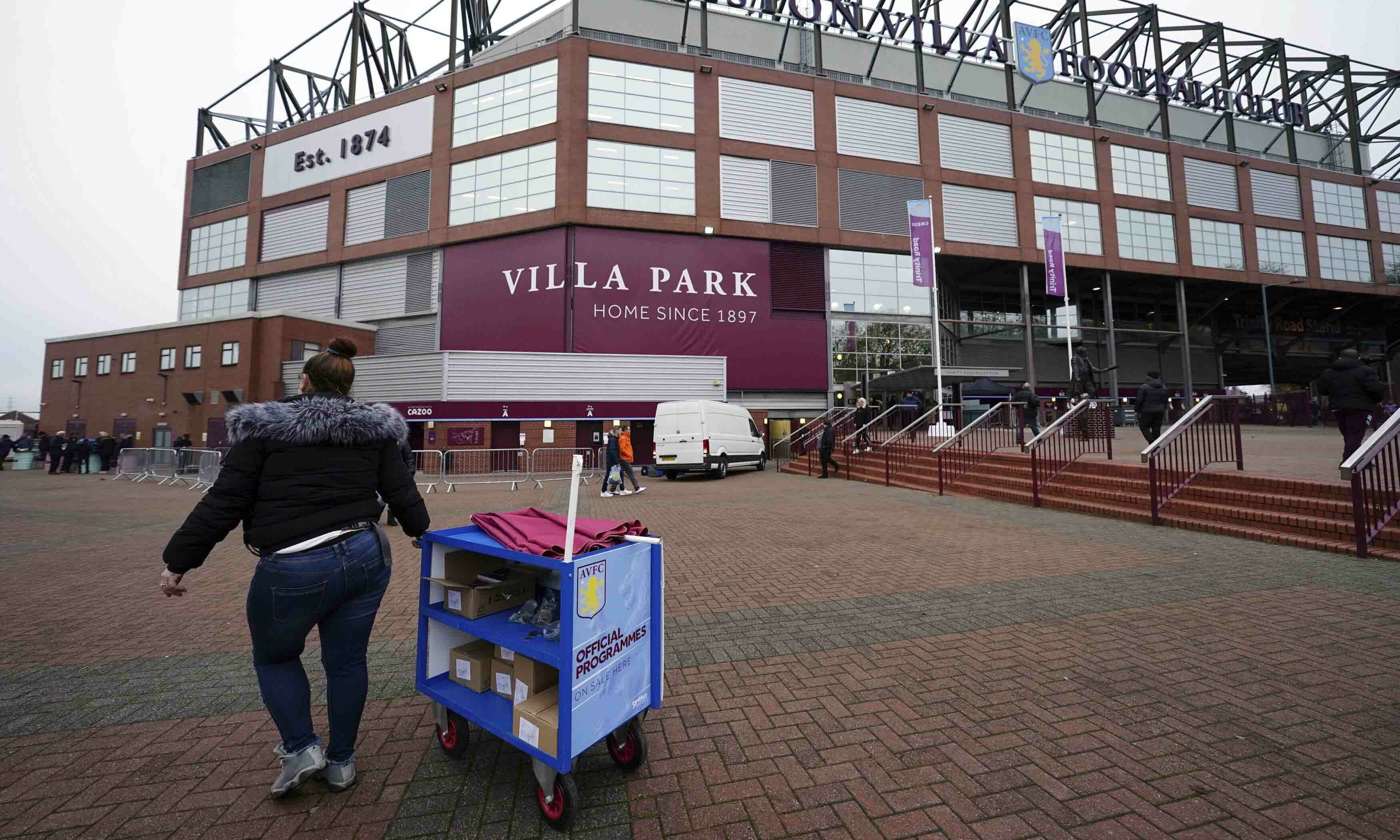 A programme seller returns takes her stall back towards the stadium following the news that Aston Villa's match against Burnley at Villa Park has been postponed, in Birmingham on Dec 18. — AP