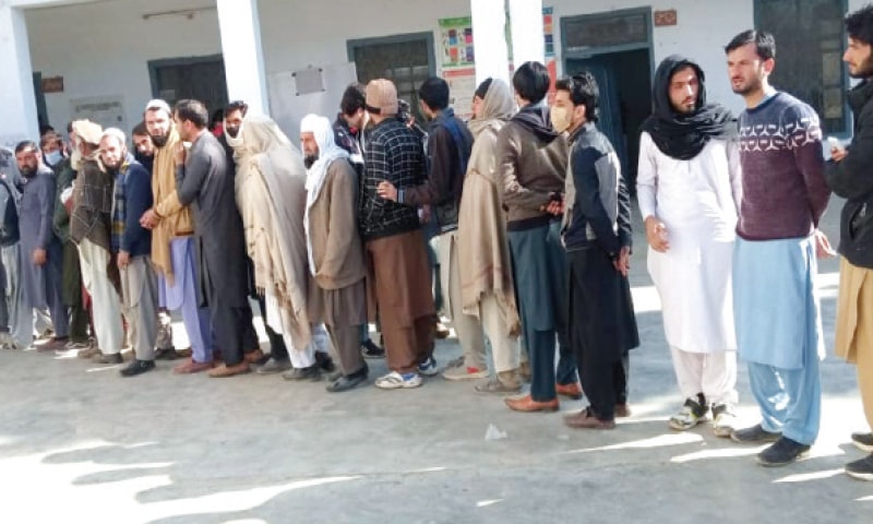 Voters line up outside a polling station in Bajaur on Sunday. — Dawn Voters line up outside a polling station in Bajaur on Sunday. — Dawn