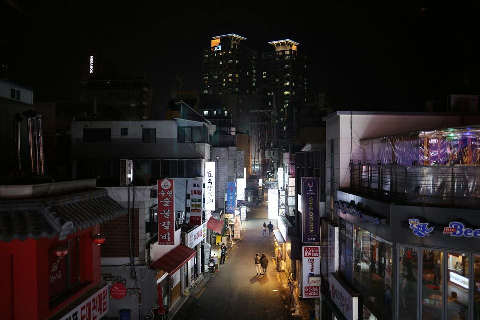 Couples leave a pub during the curfew hours starting at 9pm as part of tightened social distancing rules to contain a surge in coronavirus infections, in Seoul, South Korea, December 20. — Reuters