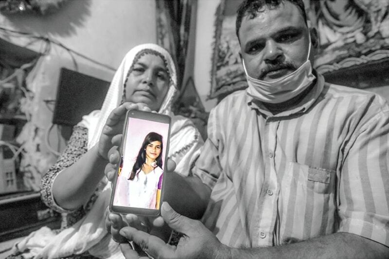 Raja Masih and Rita hold up a photo of their daughter Arzoo — Fahim Siddiqui/White Star/File