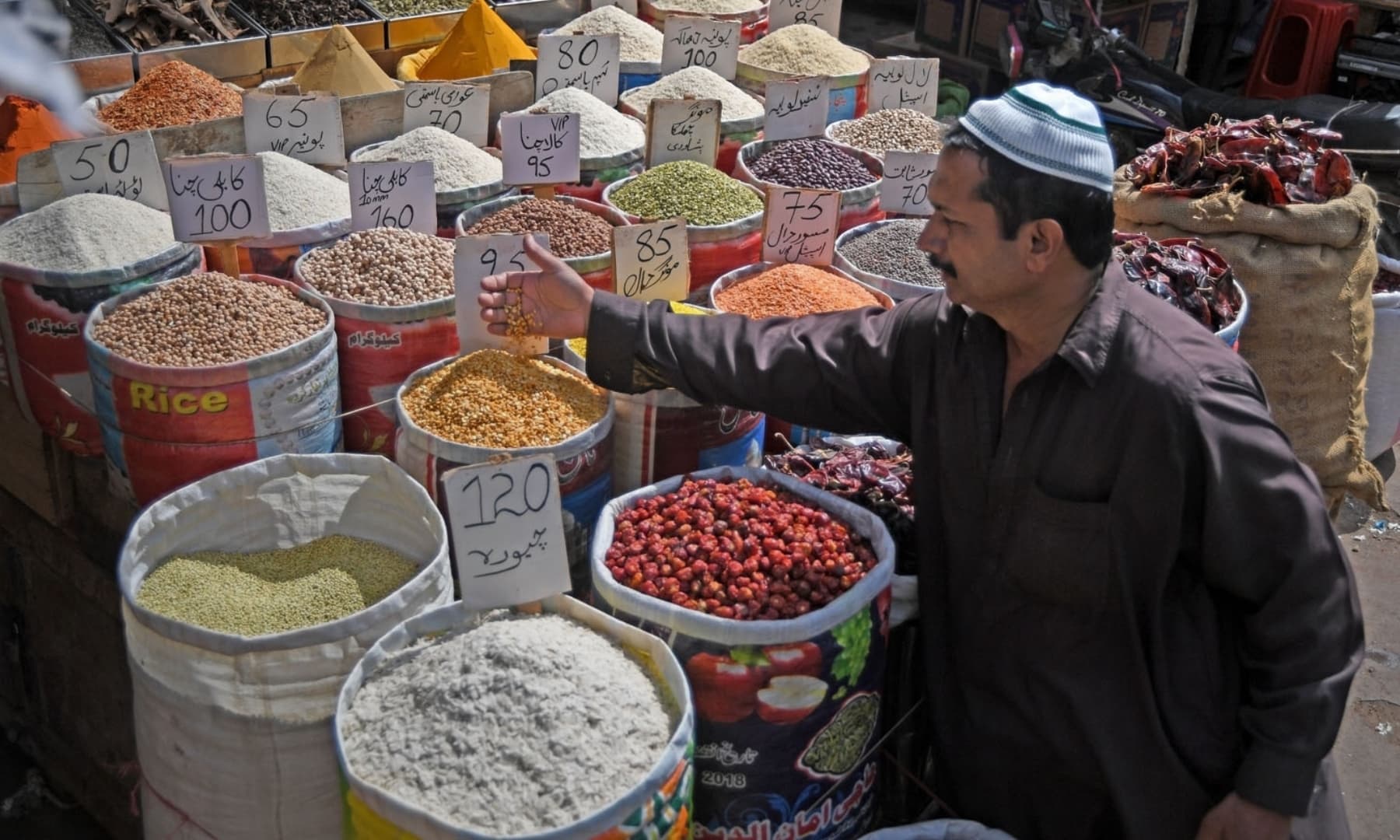 A customer checks pulses at the main wholesale market in Karachi. — AFP