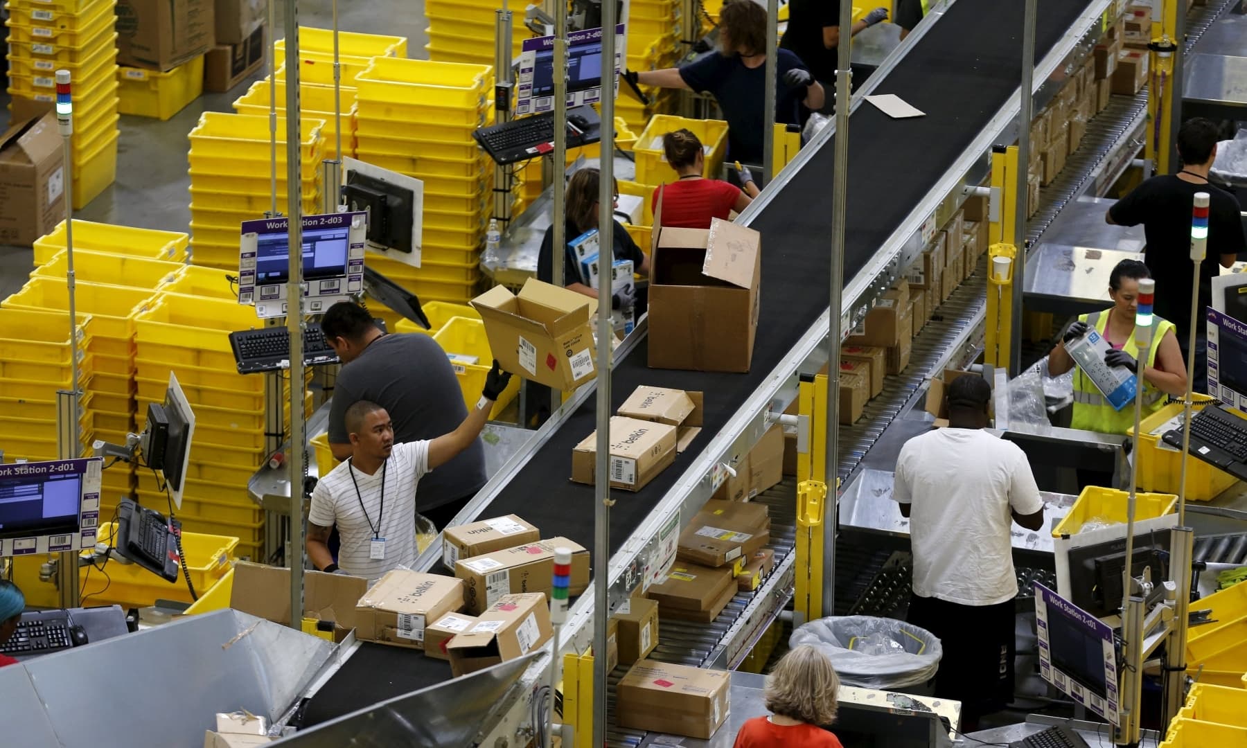 Workers sort arriving products at an Amazon Fulfilment Centre in Tracy, California, US, August 3, 2015. — Reuters